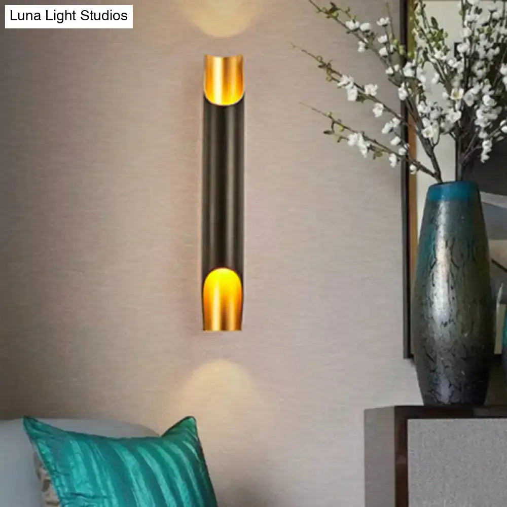 Modern white metal fixture wall sconce with gold accents and black body featuring warm focused lighting for living room