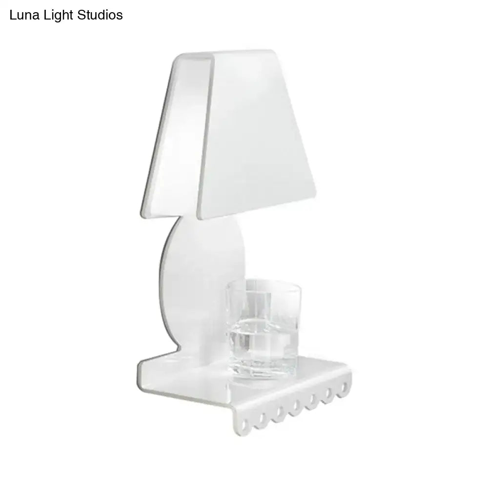 Clear acrylic table lamp with minimalist design and integrated glass coaster paired with modern white metal trapezoid wall sconce light for bedroom
