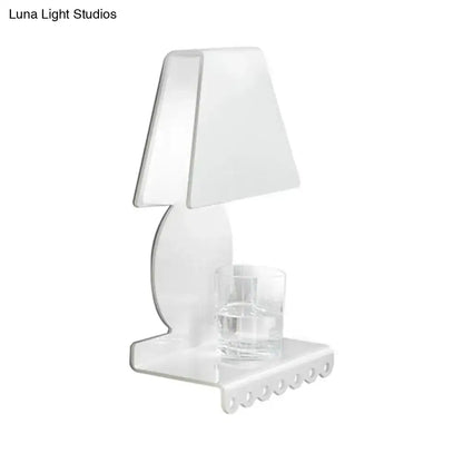 Clear acrylic table lamp with minimalist design and integrated glass coaster paired with modern white metal trapezoid wall sconce light for bedroom