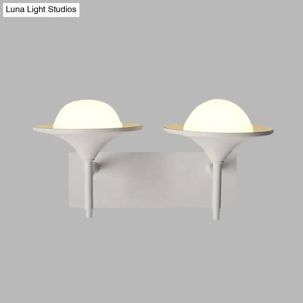Modern white metallic flared wall sconce with frosted dome and gold-toned base for bedroom LED lighting