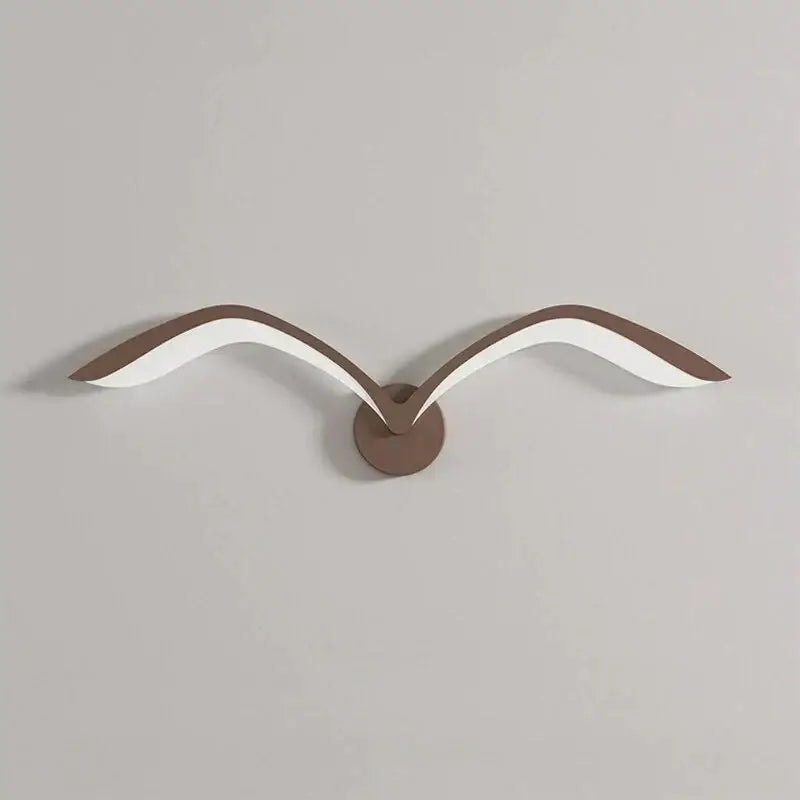 Modern nordic avian style wall lamp with white and brown acrylic wings on a bronze circular indoor wall sconce