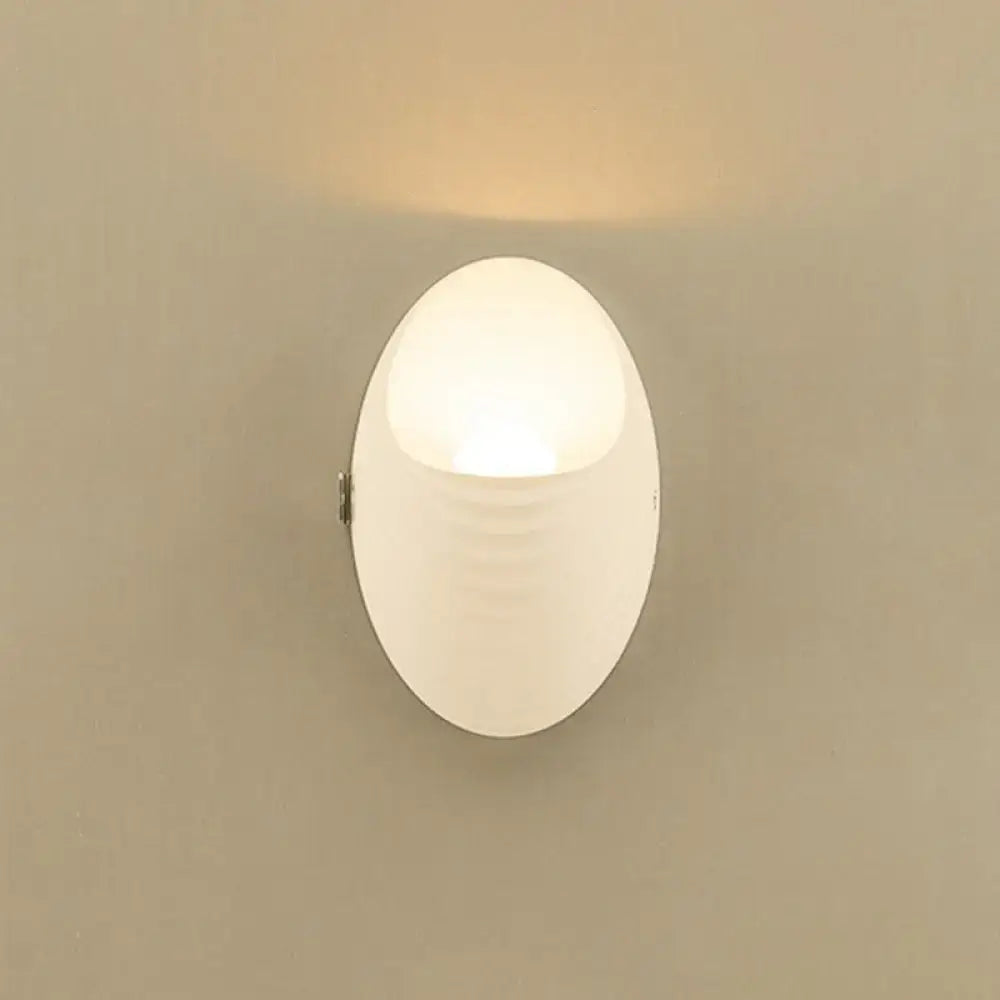 A modern white nordic wall lamp with frosted acrylic diffuser and subtle ridges 110v-120v fixture type for bedroom