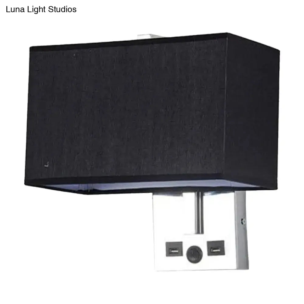 Black rectangular fabric lampshade mounted on a white metal base with two usb ports and a central power button.