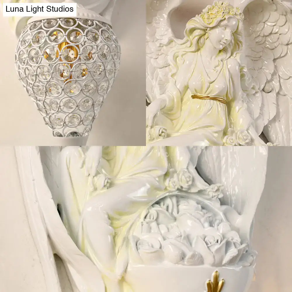 Modern white resin angel wall light with gold accents and detailed wings holding a basket of roses for bedroom angel wall use