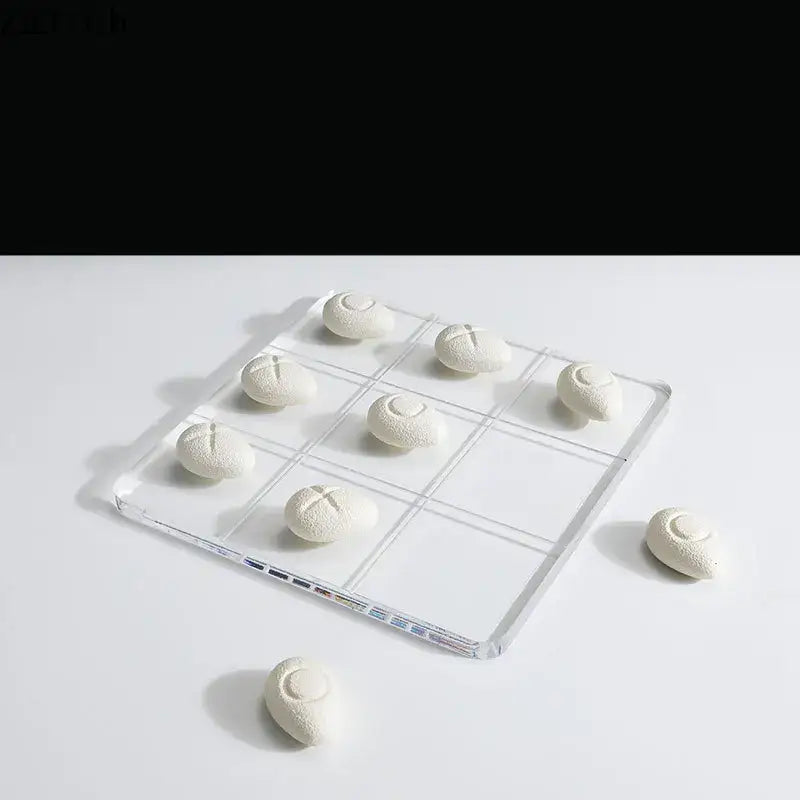 Modern clear acrylic tic-tac-toe board with white textured resin pieces for living room decor by decorbites