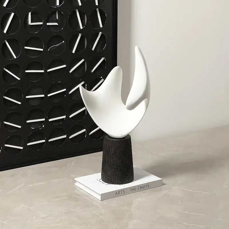 Modern white resin sculpture with smooth flame-like curves on dark wood pedestal for decorbites abstract living room decorbites abstract hollowed-out style