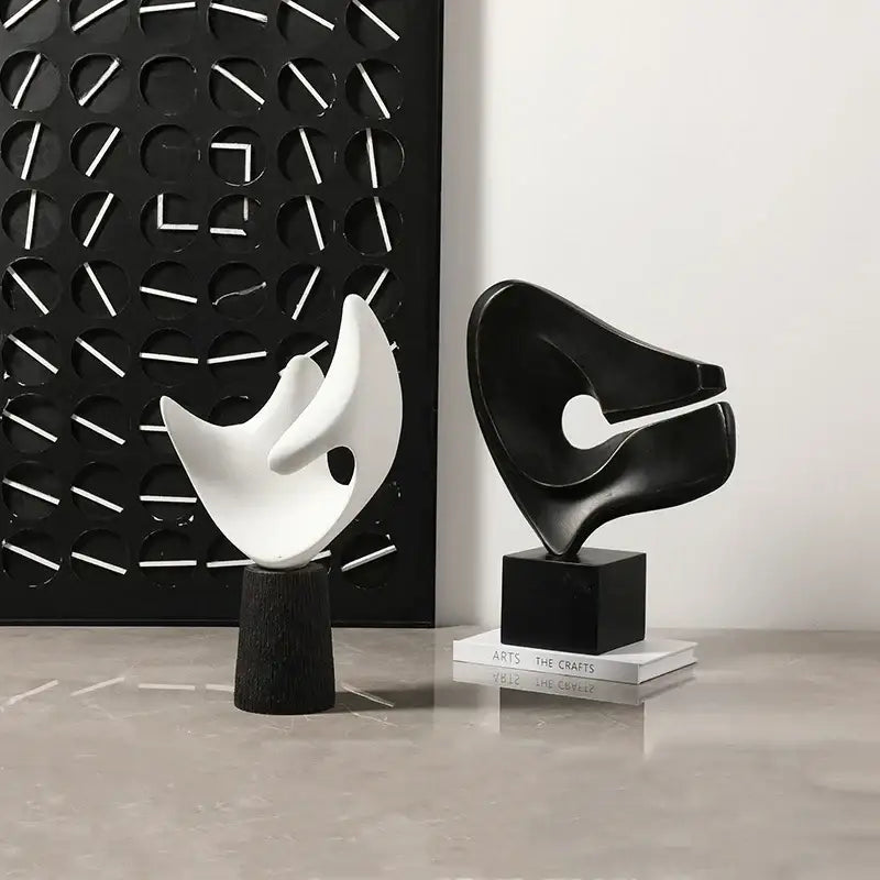 Modern white resin sculpture with black abstract decorbites abstract hollowed-out design on wood pedestal for living room decor
