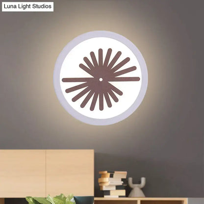 Modern white sector leaf pattern wall light with circular illuminated face and dark brown sunburst design for living room