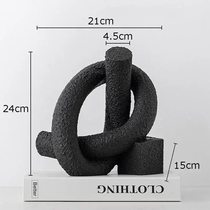 Black textured abstract twisted knot sculpture with interlocking rings on white base for living room decor