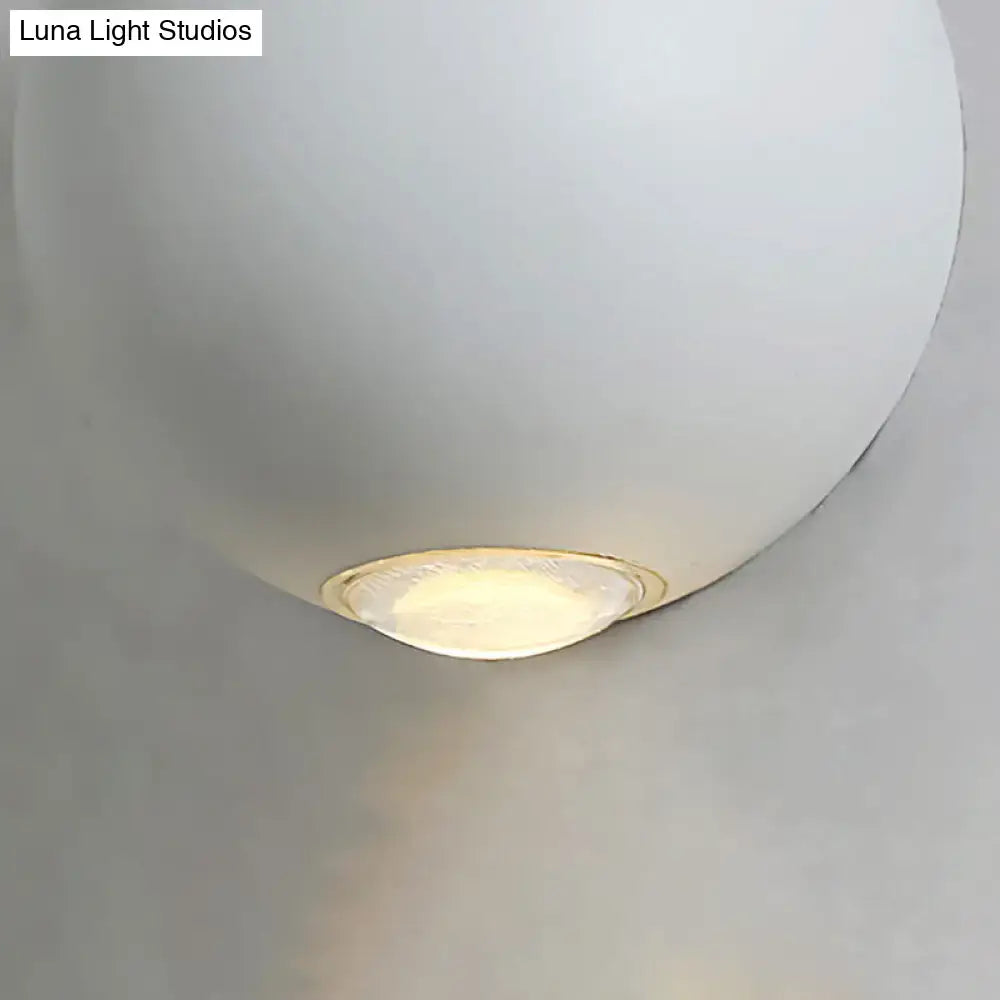 A sleek matte white spherical wall light fixture with warm-toned led light for modern outdoor use