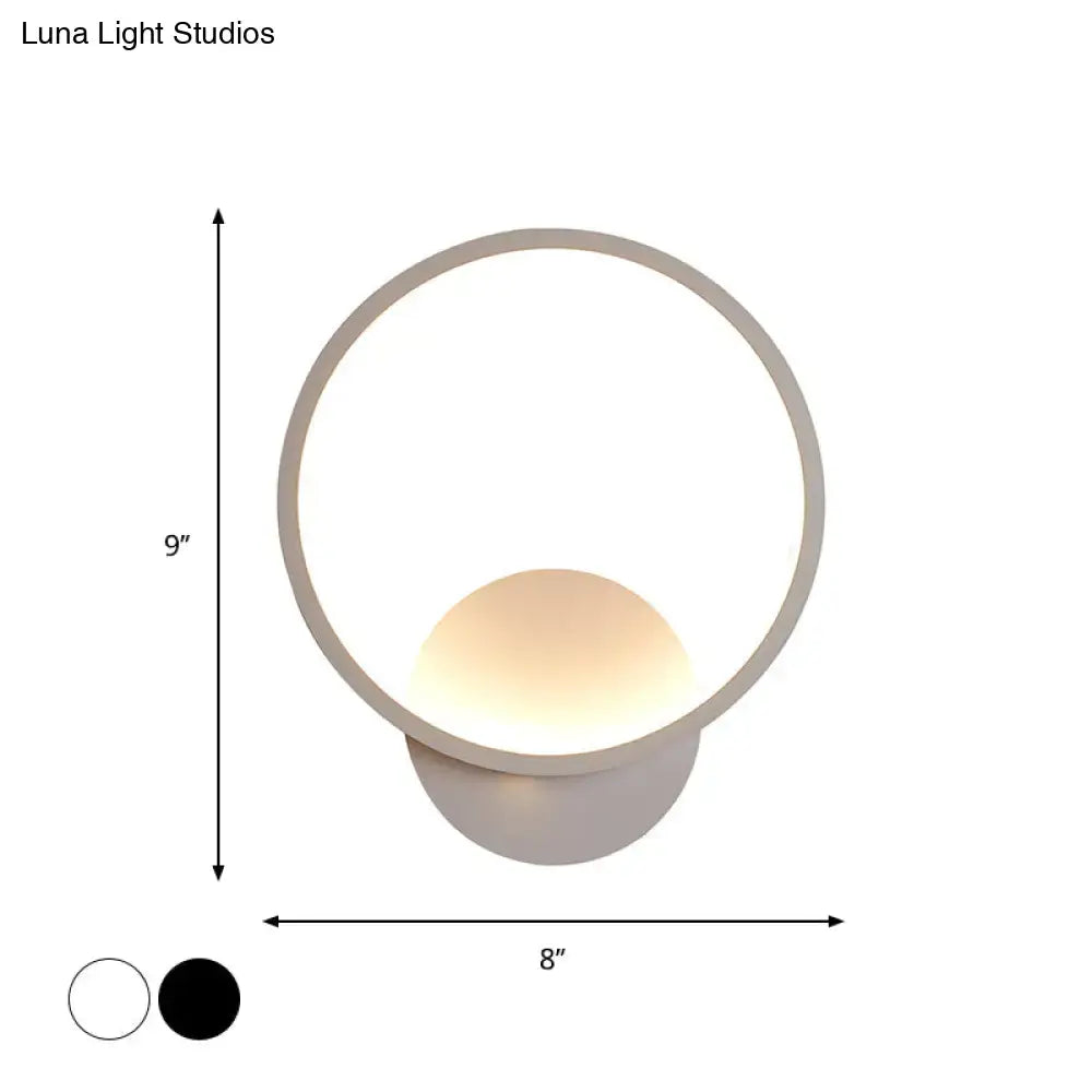 Modern white square bedside wall lamp with a sleek circular black white frame and warm glowing spherical light
