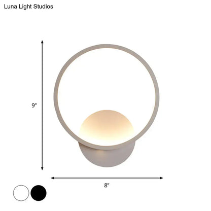 Modern white square bedside wall lamp with a sleek circular black white frame and warm glowing spherical light