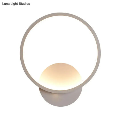 Modern white square bedside wall lamp with a black white minimalist circular frame and warm spherical light