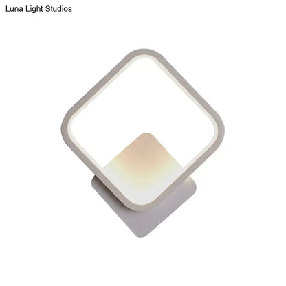 Modern white square bedside wall lamp with a black white geometric frame and soft ambient lighting for minimalist bedrooms
