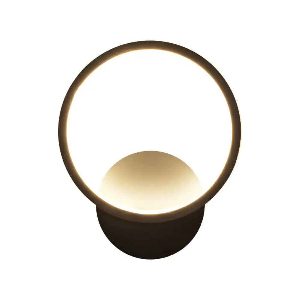 Modern black white bedside wall lamp with circular metal frame and warm glowing translucent diffuser for minimalist bedroom lighting