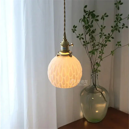 Modern white textured glass ceramic led pendant light with warm-toned brass fixture and twisted cord for kitchen decorbites ceramic led pendant