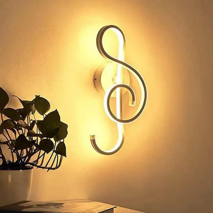 A modern white treble clef led wall sconce featuring an illuminated design for bedroom lighting use