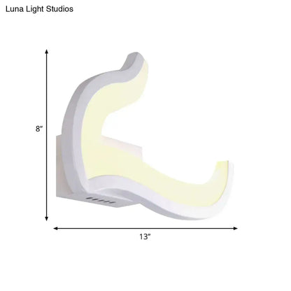 Modern white u-shaped led wall sconce with sleek curved design emitting warm yellow light for bedroom use