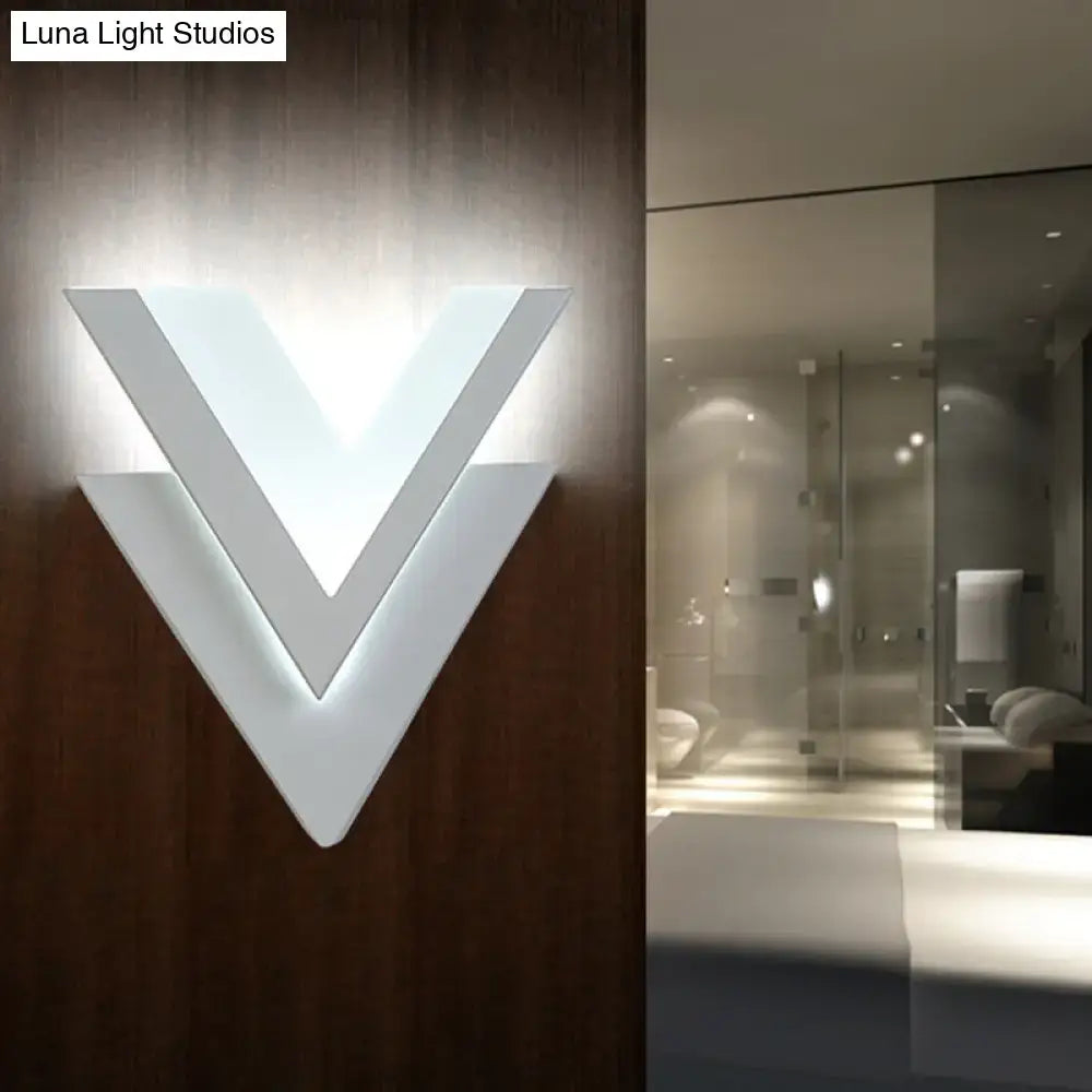 Modern white v-shaped wall sconce with layered geometric design.