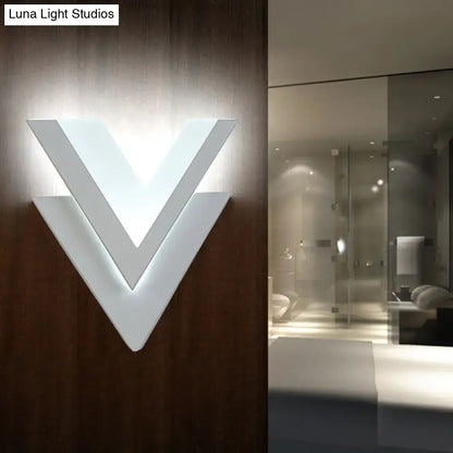 Modern white v-shaped wall sconce with layered geometric design.
