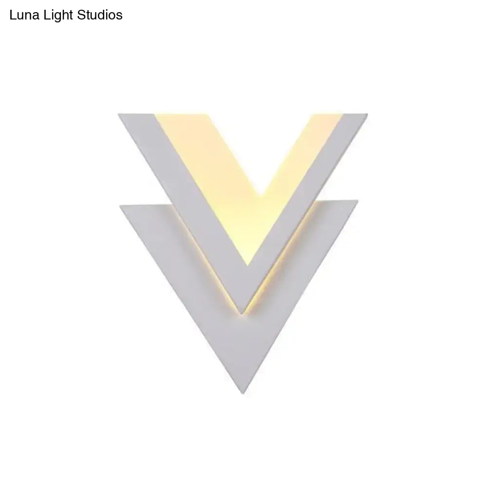 Modern white v-shaped led wall mounted light with matte geometric panels and warm yellow led wall strip illumination