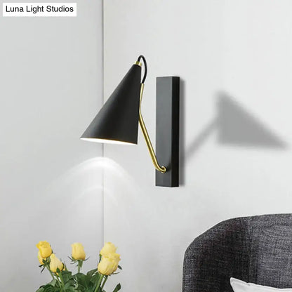 Black finish conical wall lamp with gold articulated arm designed as a modern bedroom sconce