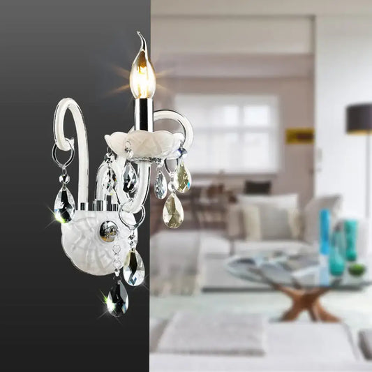 Modern white wall sconce light with silver accents and teardrop crystal decoration for living room lighting