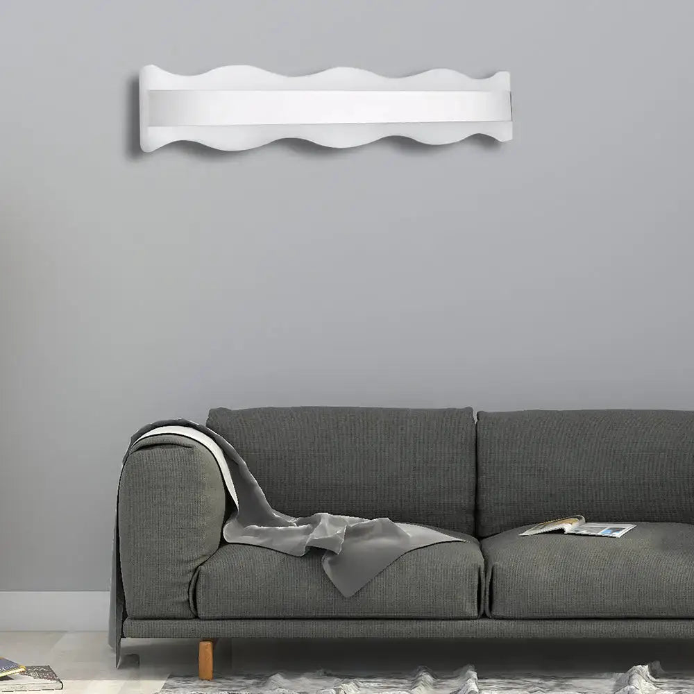 White warm modern light fixture with a sleek wavy design ideal for bathroom wall sconce lighting