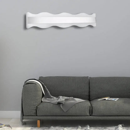 White warm modern light fixture with a sleek wavy design ideal for bathroom wall sconce lighting