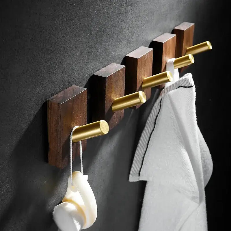 Modern wood and brushed gold wall hook row with brass brushed cylindrical pegs for kitchen decorbites use