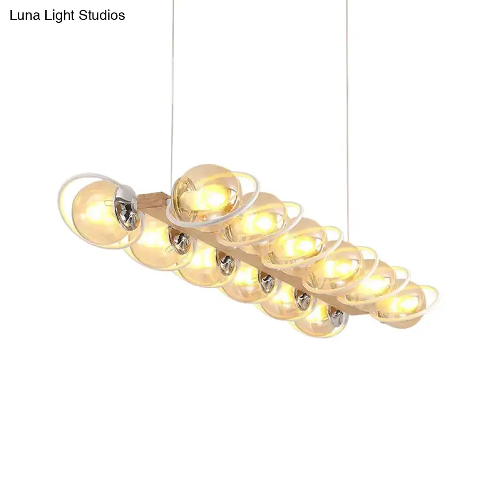 Modern pendant light with warm cognac bubble shade glass orbs suspended from a wooden base for shade island lighting