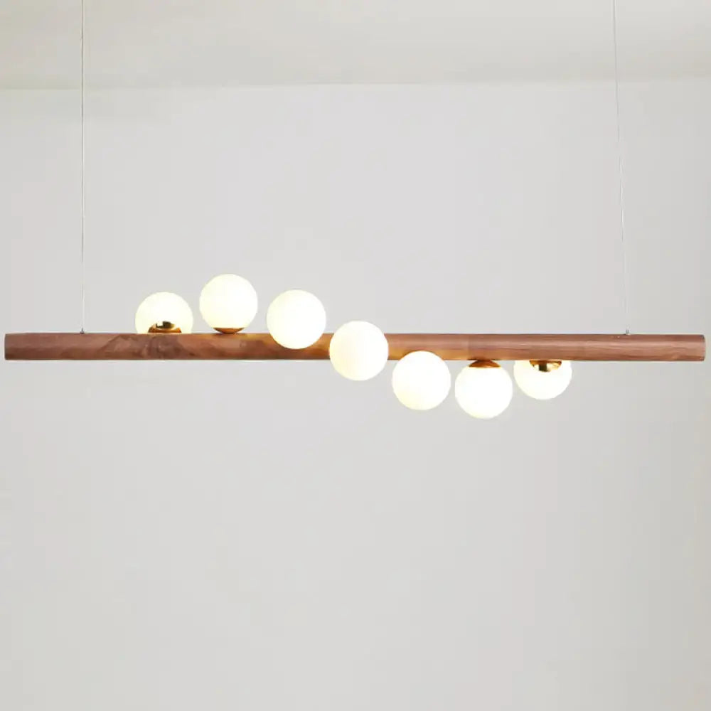 DecorBites minimalistic milk glass suspension light with warm wood bar and frosted globes for dining room lighting