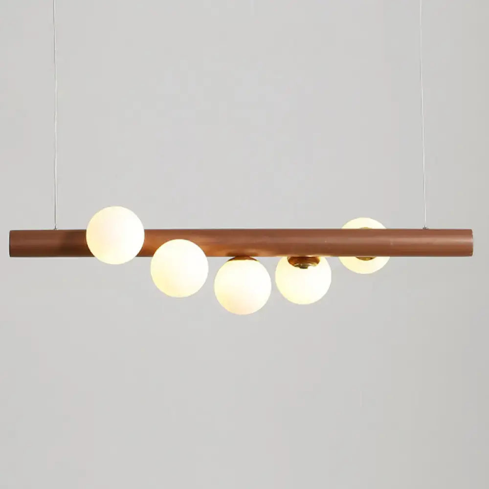Modern copper suspension light with five frosted milk glass globes for elegant dining room lighting by DecorBites™
