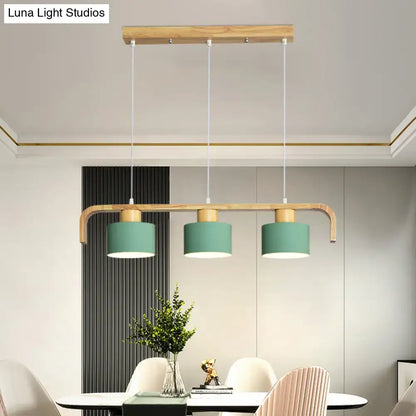 Modern wood and mint green three-light pendant lamp with matte teal shades and white cords for dining room kitchen use
