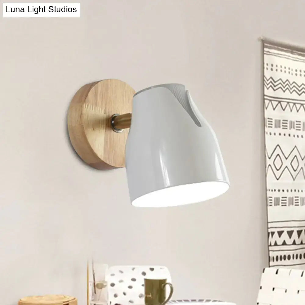 Modern wall light with matte white metal bud shade, wooden circular backplate, and brass accents as light source