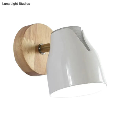 Modern wall light with white ceramic shade, natural wood backplate, brass accent, and metallic bud shade as light source