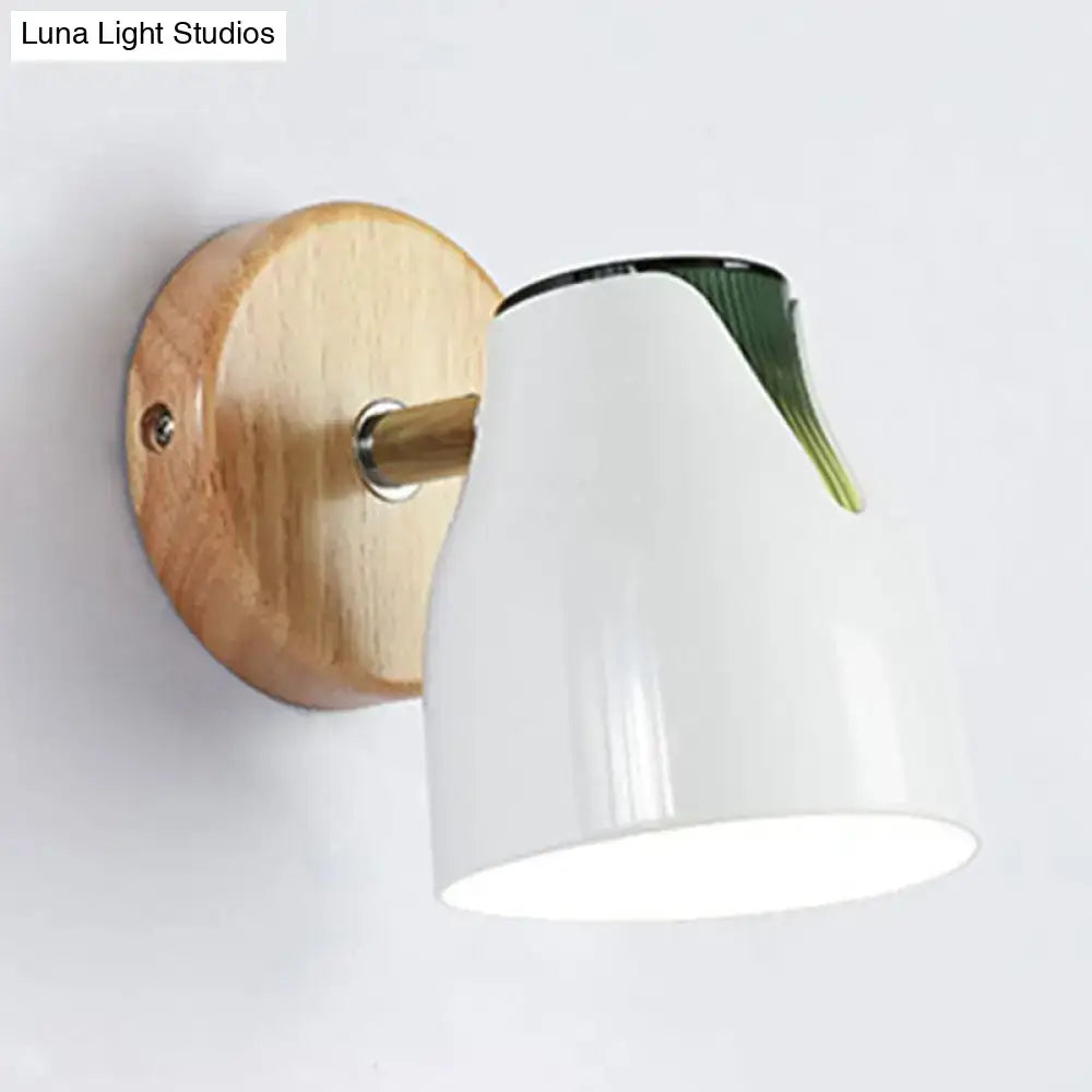 Modern wall light featuring a white ceramic light source with a wooden base and metallic bud shade accent
