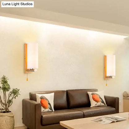 Modern wood and white glass wall sconce with warm wooden frame frosted shade and pull chain light type for bedroom