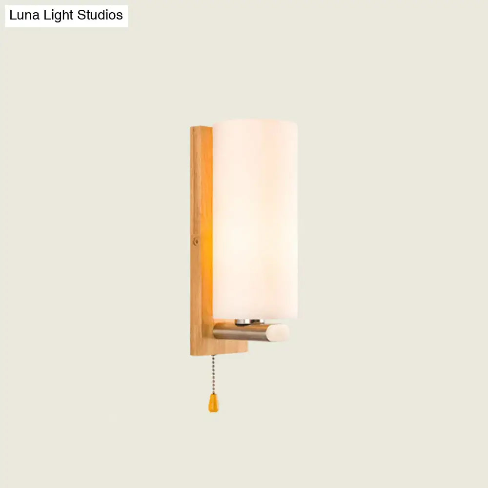 Modern wood and white glass wall sconce with pull chain light featuring warm wooden backplate and frosted glass shade