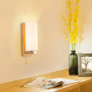 Modern wood and white glass wall sconce with frosted shade and pull chain light type for bedroom lighting