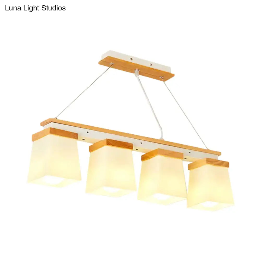 Modern minimalist pendant light with four warm white lights and square frosted glass shades on wooden frame for dining room