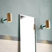Pair of modern wood wall sconces with yellow green bases and light wood shades ideal for bathroom lighting