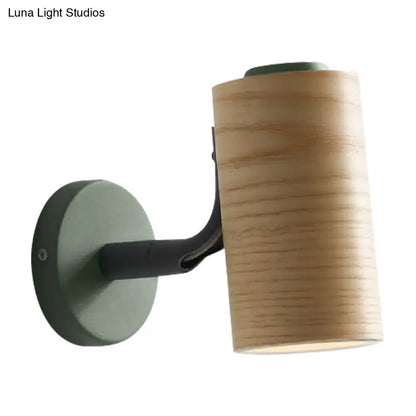 Modern wall-mounted lamp with cylindrical wooden shade and matte yellow green metal bracket for bathroom use
