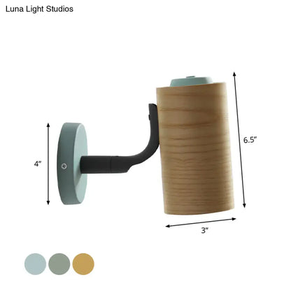 Modern wall-mounted lamp with cylindrical wooden body and black metal arm in yellow green for bathroom use