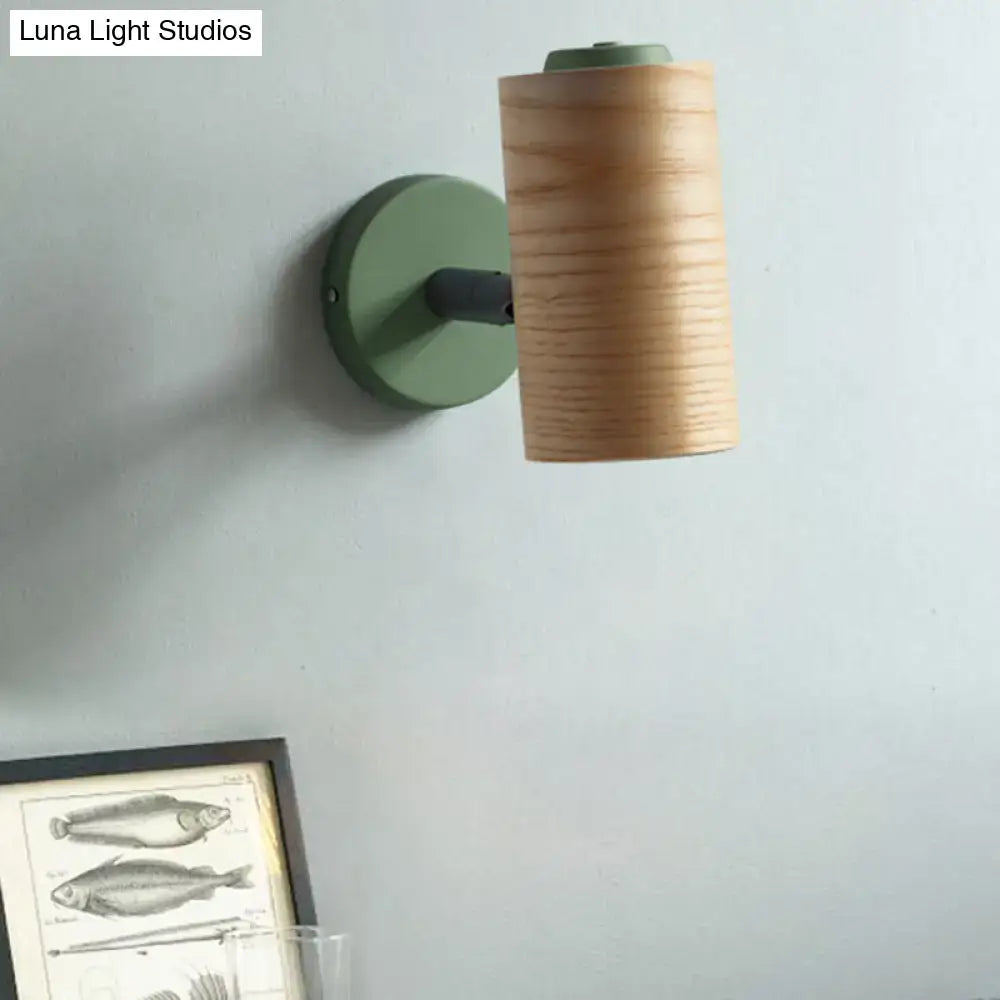 Modern wood and yellow green wall sconce pair featuring a cylindrical wooden shade and sage green metal base for bathroom use