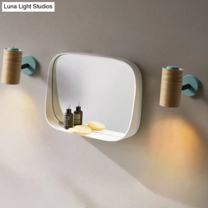 Modern white rectangular mirror with integrated shelf and yellow green blue wood cylindrical wall sconces for bathroom use