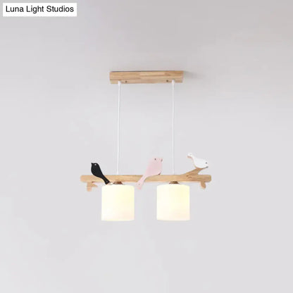 Wooden branch-style pendant light with three painted birds and two frosted glass shades for kitchen island or barrel island