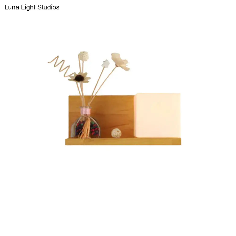 Modern wood floating shelf with beige wall lamp and sconce light holding glass diffuser and dried flower reeds