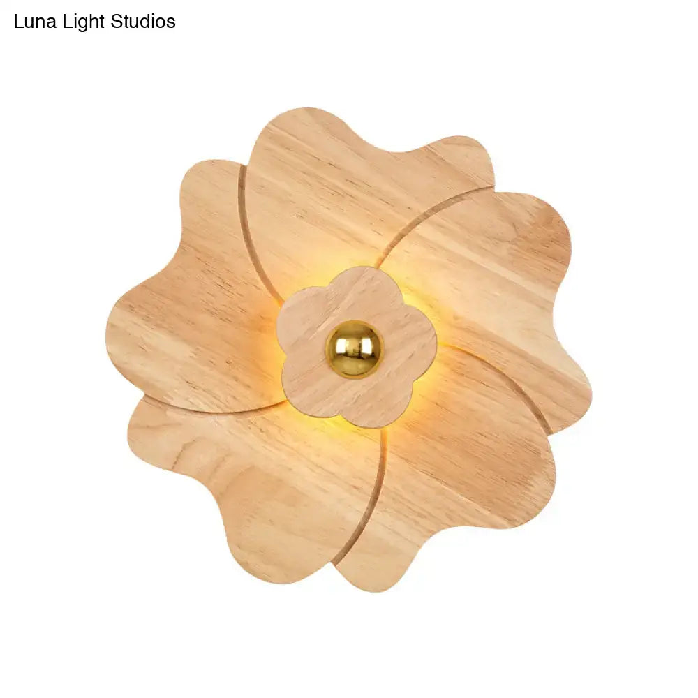 A warm-toned wooden flower wall light sconce with a central brass sphere for modern bedroom decor