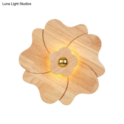 A warm-toned wooden flower wall light sconce with a central brass sphere for modern bedroom decor